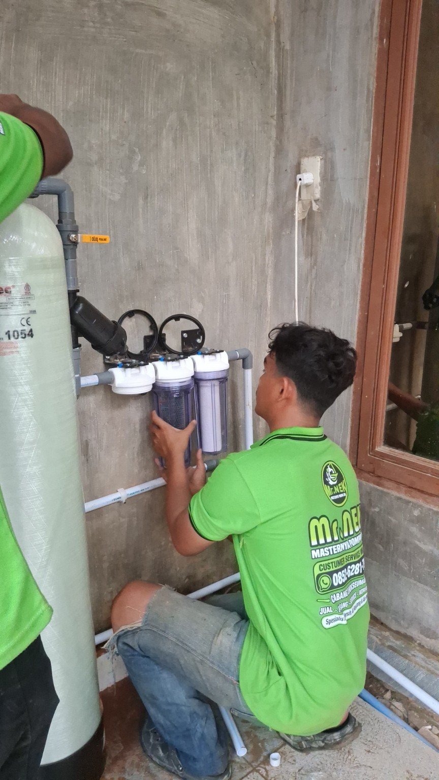 Teknisi mengerjakan rumah filter di dinding